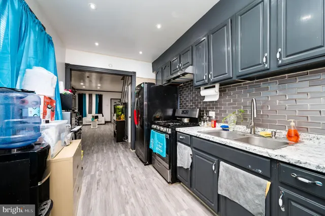 a kitchen with a sink a stove and cabinets