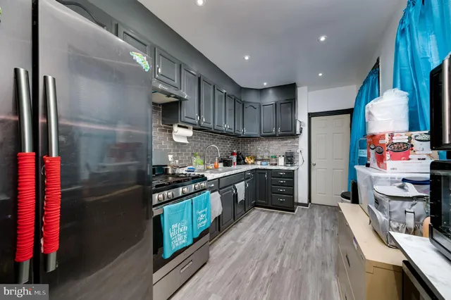 a kitchen with stainless steel appliances granite countertop a refrigerator a stove top oven a sink and dishwasher