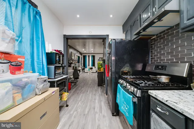 a kitchen with stainless steel appliances granite countertop a stove and a wooden floors