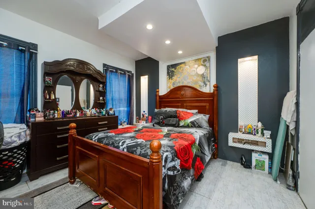 a bedroom with a bed and a mirror on the dresser