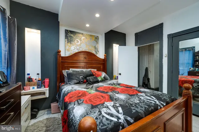 a bedroom with a bed tv and a window