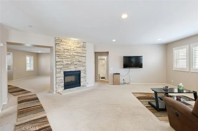 a dining room with furniture a potted plant and a kitchen view