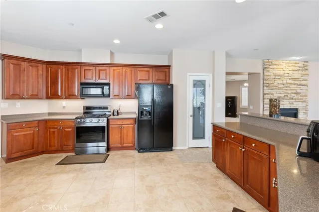 a kitchen with stainless steel appliances kitchen island granite countertop a stove a sink a microwave a counter top space and cabinets