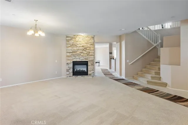 an empty room with windows and fireplace