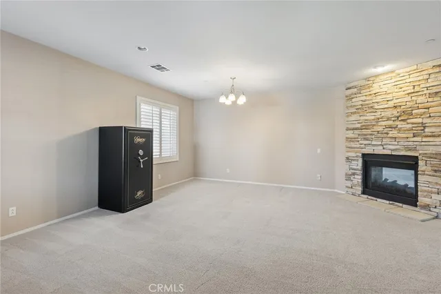 a view of an empty room with a fireplace and a window