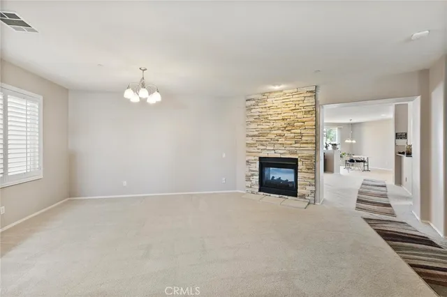 a living room with furniture a fireplace and a dining table with wooden floor
