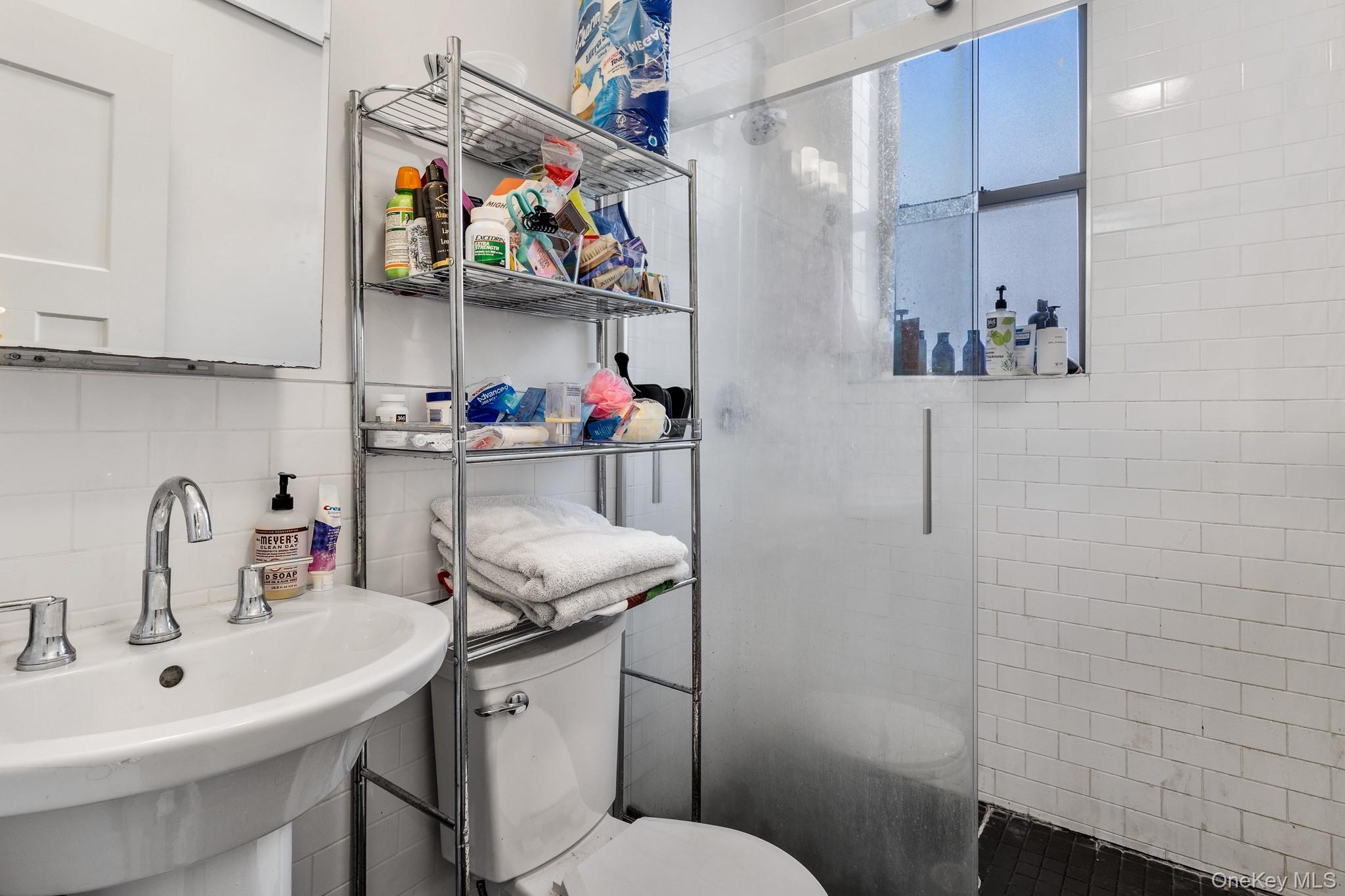 68-51 Fresh Pond Road, Unit 2B Queens, NY 11385 - Photo 13 of 15 Bathroom featuring a shower stall, tasteful backsplash, and tile walls