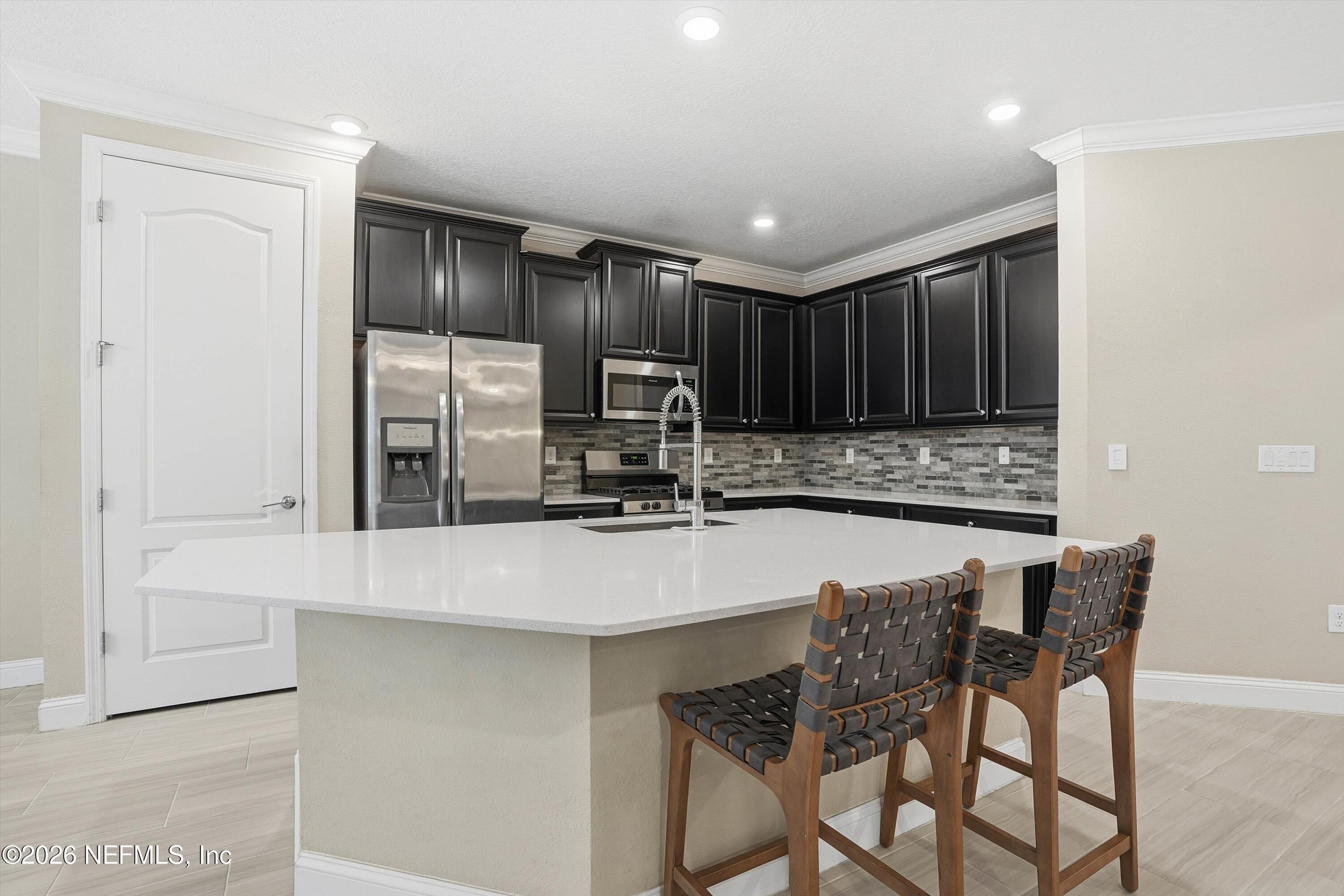 309 Coco Point St. Augustine, FL 32092 - Photo 13 of 50 a kitchen with kitchen island granite countertop wooden cabinets and a refrigerator