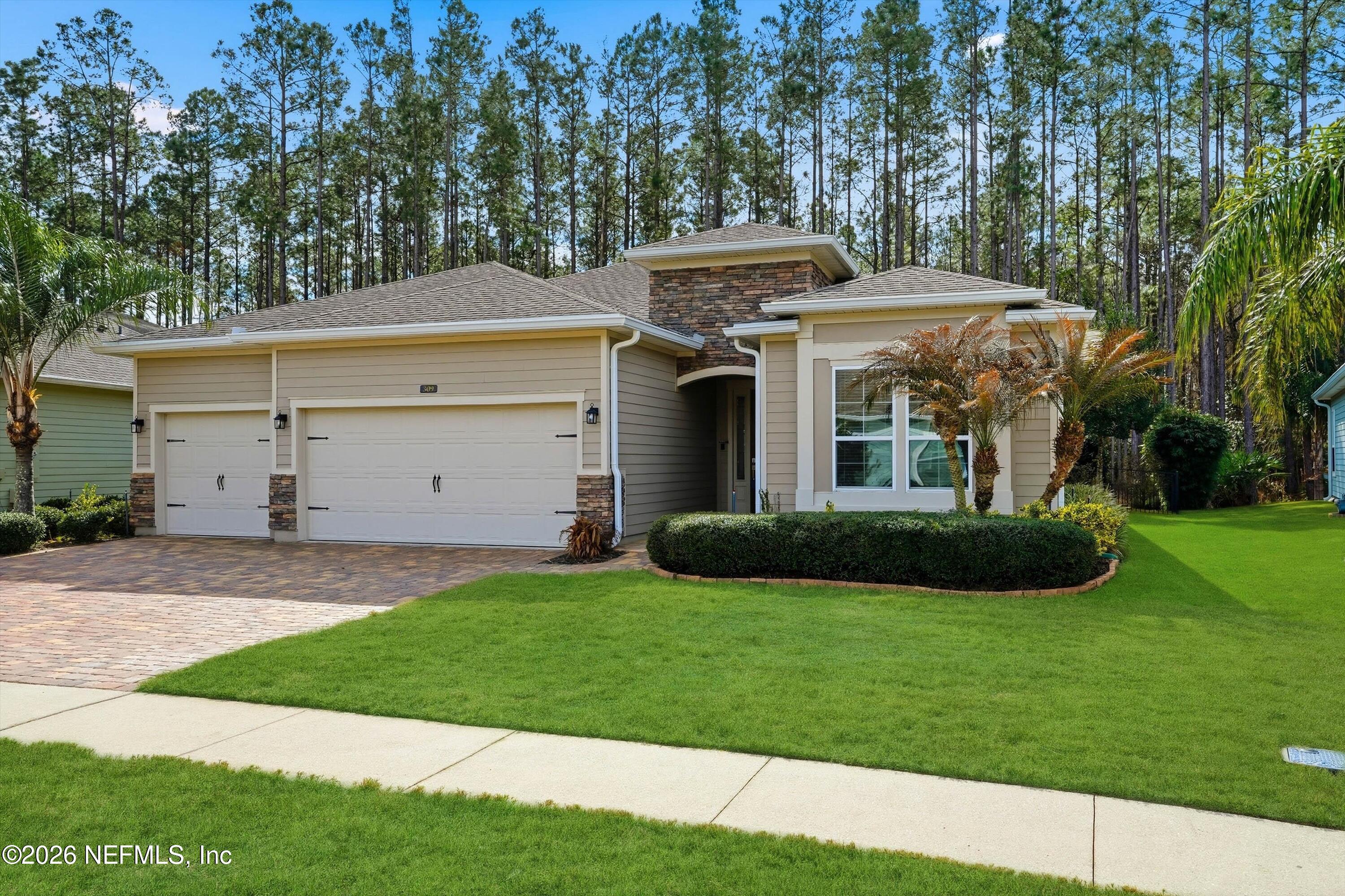 309 Coco Point St. Augustine, FL 32092 - Photo 2 of 50 a view of a white house with a small yard and a large tree