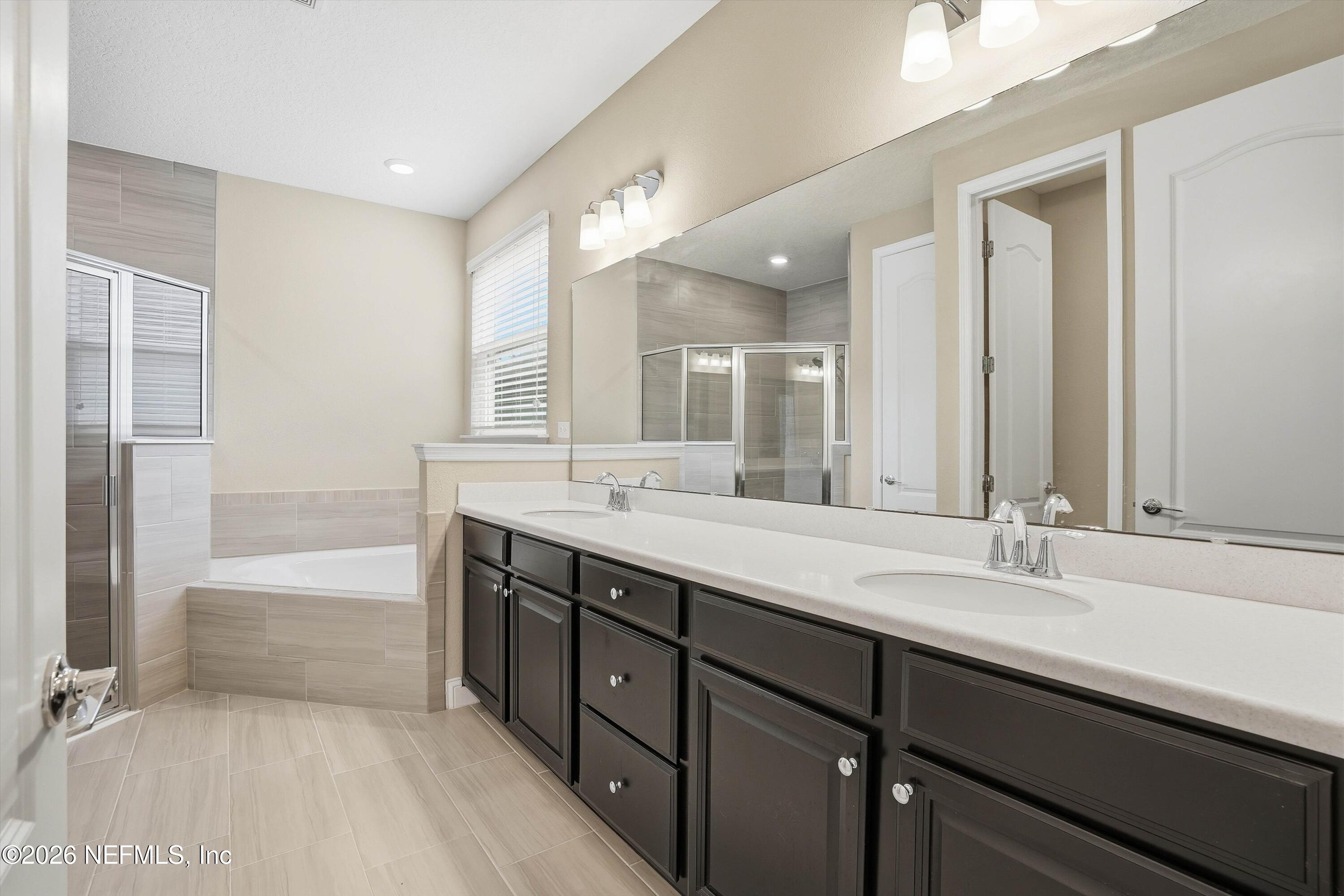 309 Coco Point St. Augustine, FL 32092 - Photo 24 of 50 a bathroom with a sink double vanity granite tub shower and a mirror