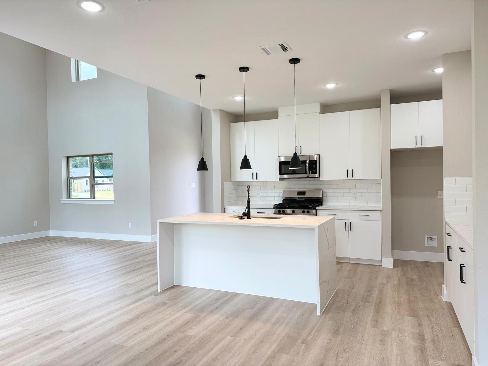 2615 Liguria Ln Spring Spring, TX 77388 - Photo 5 of 29 a kitchen with stainless steel appliances granite countertop a stove a sink a refrigerator and white cabinets with wooden floor