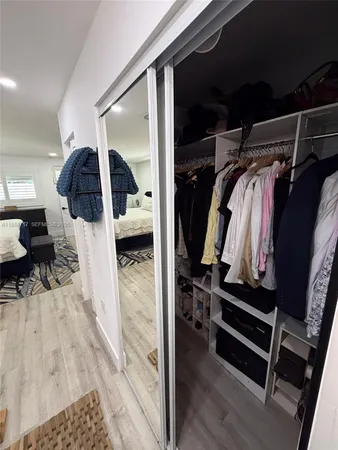 a kitchen with stainless steel appliances a dining table chairs refrigerator and microwave