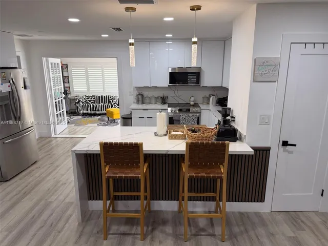 a kitchen with stainless steel appliances a refrigerator and a stove top oven