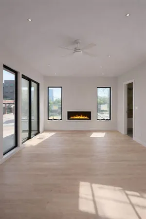 a view of an empty room with window and wooden floor