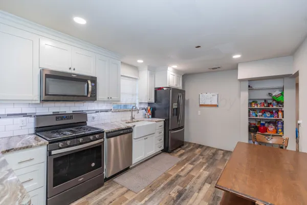 a kitchen with white cabinets and stainless steel appliances