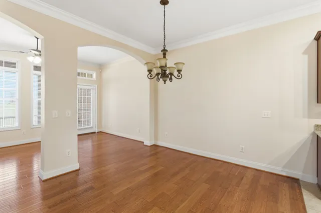 a view of a room with wooden floor and chandelier