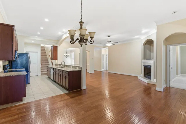 a large kitchen with a center island wooden floor stainless steel appliances and cabinets