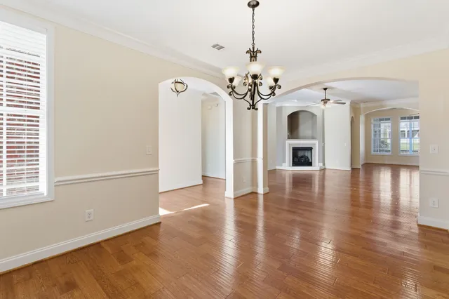 a view of a big room with wooden floor windows and a chandelier