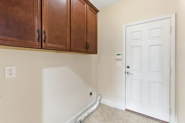 an empty room with chandelier fan and windows
