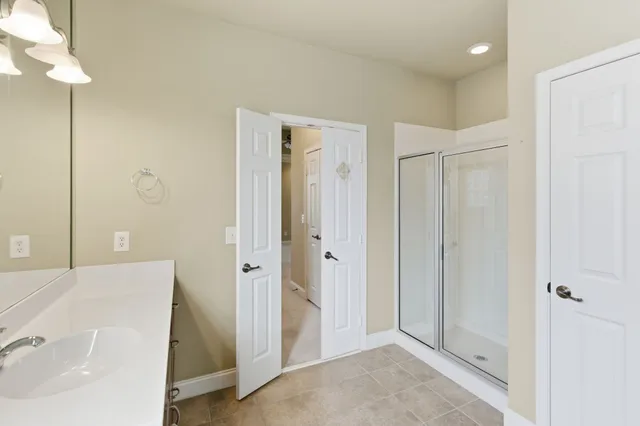 an empty room with windows and chandelier fan