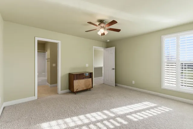 a view of a livingroom with a ceiling fan and window