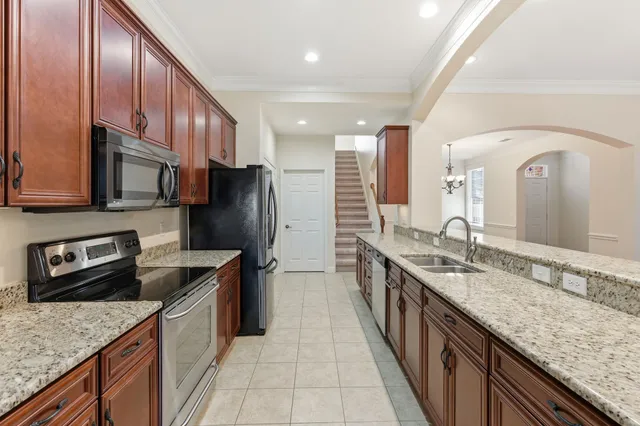 a kitchen with stainless steel appliances granite countertop a sink stove and refrigerator