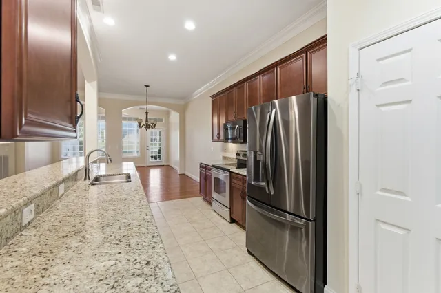 a kitchen with stainless steel appliances granite countertop a refrigerator a stove and a sink
