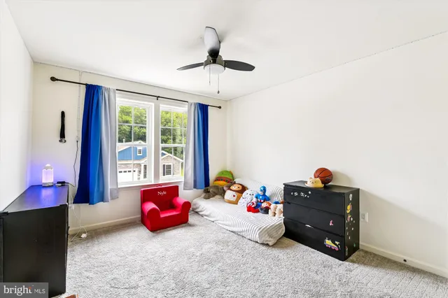a living room with couches and kitchen view with wooden floor