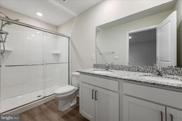a bathroom with a granite countertop sink toilet and shower