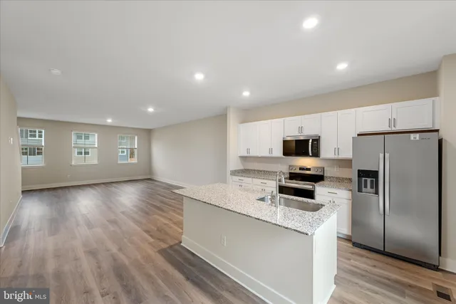 a kitchen with stainless steel appliances a refrigerator sink and microwave