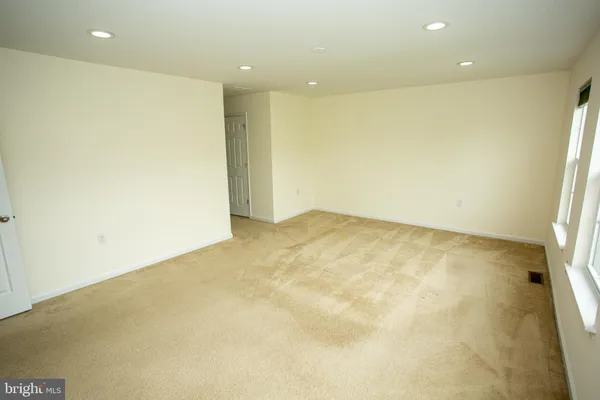 an empty room with wooden floor and glass window