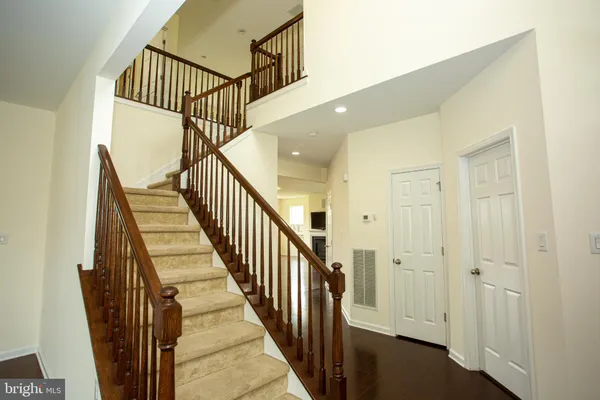 a view of staircase with wooden floor and white walls