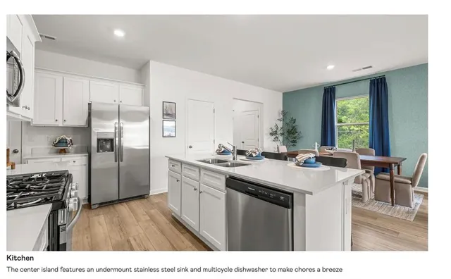 a kitchen with a sink a counter top space stainless steel appliances and cabinets