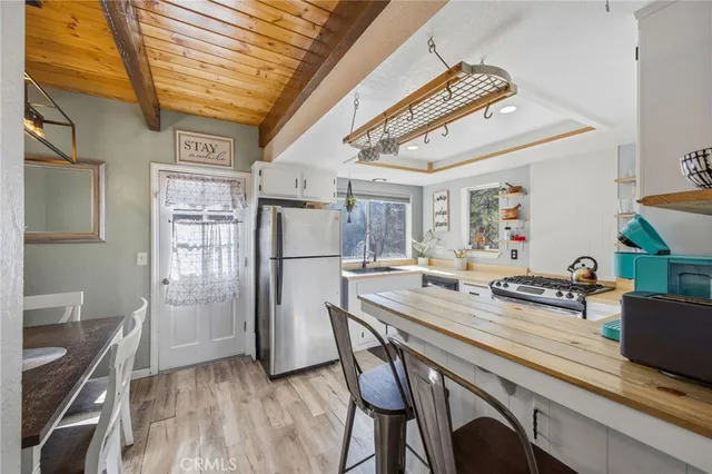 a kitchen with stainless steel appliances granite countertop a refrigerator a sink dishwasher and a stove with wooden floor