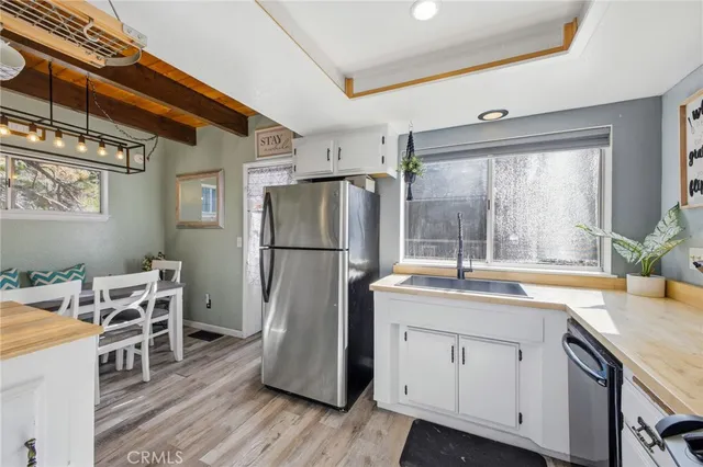 a kitchen with a refrigerator a sink and dishwasher with wooden floor
