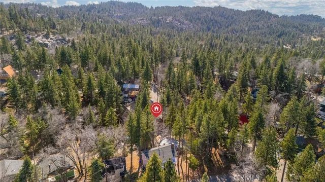 a view of a house with a yard and large tree