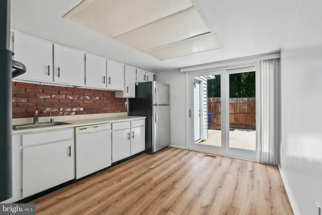 a kitchen with granite countertop white cabinets and refrigerator