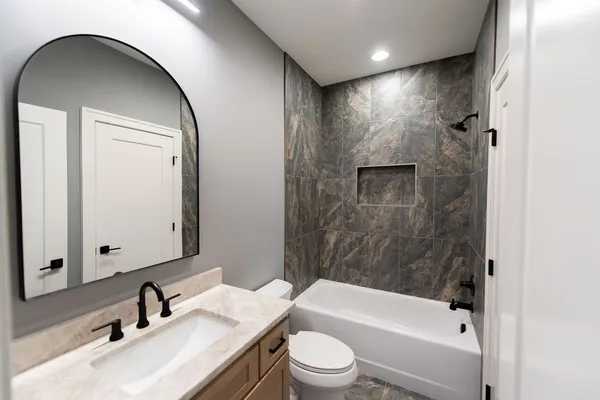 a bathroom with a granite countertop sink mirror and toilet