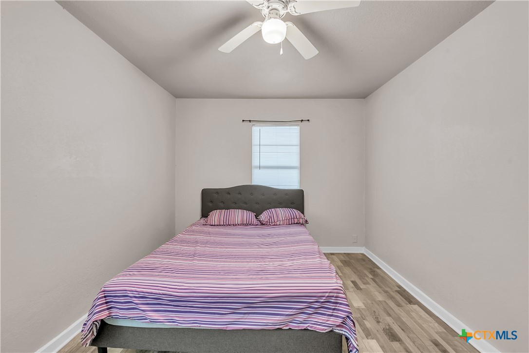 1001 West 8th Street Cameron, TX 76520 - Photo 11 of 20 a bedroom with a bed and a chandelier