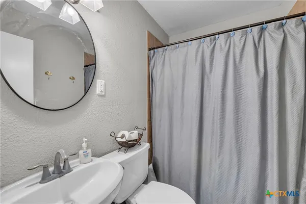 a bathroom with a sink mirror and toilet