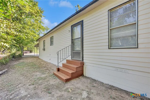a view of a small house with backyard