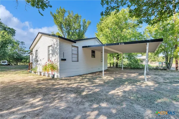 a view of a house with a backyard and a tree
