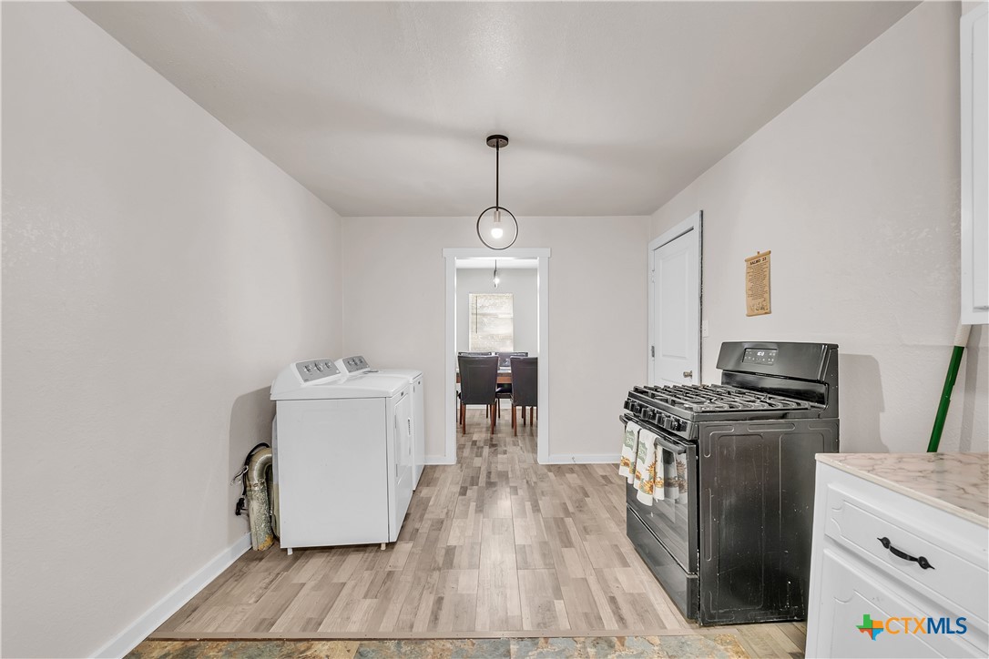1001 West 8th Street Cameron, TX 76520 - Photo 9 of 20 a kitchen with a stove a sink and a refrigerator