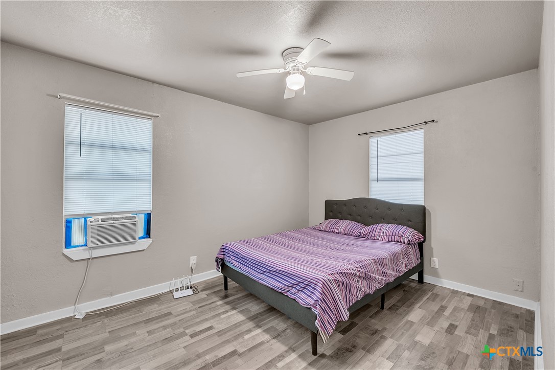 1001 West 8th Street Cameron, TX 76520 - Photo 10 of 20 a bedroom with a bed and a chandelier
