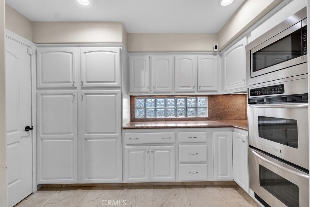 11677 Seminole Circle Porter Ranch, CA 91326 - Photo 27 of 69 a kitchen with granite countertop white cabinets stainless steel appliances and sink