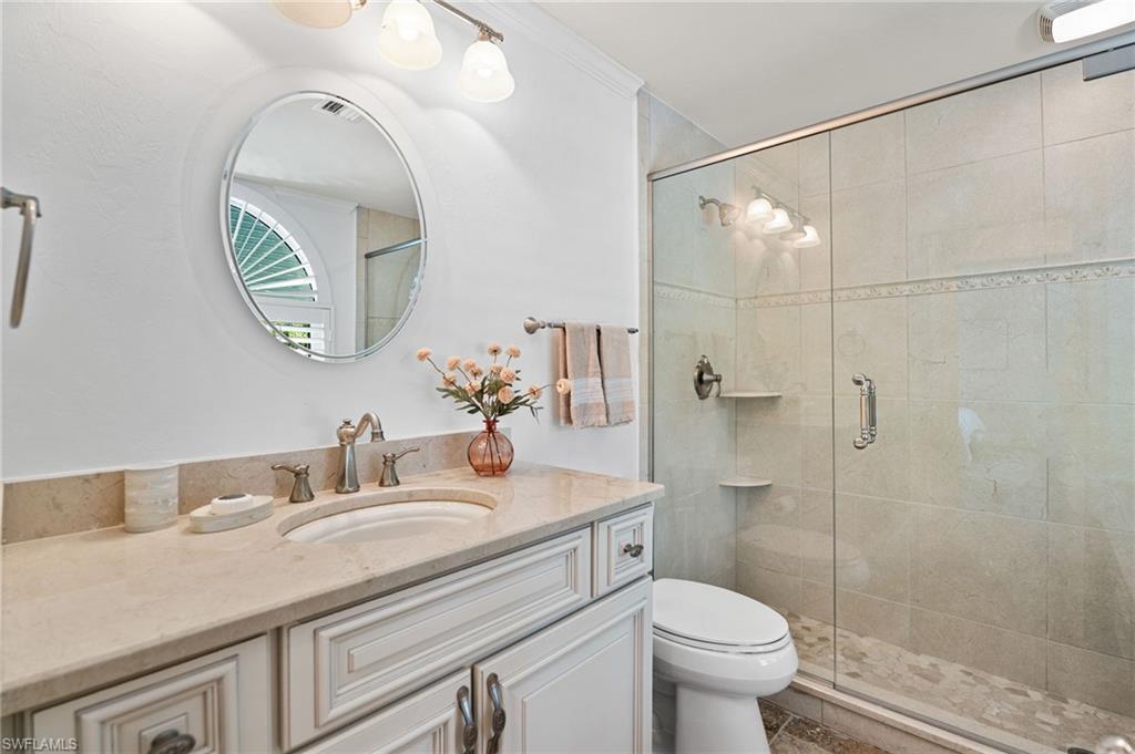 2201 Beacon Lane Naples, FL 34103 - Photo 18 of 25 a bathroom with a sink a toilet and a mirror