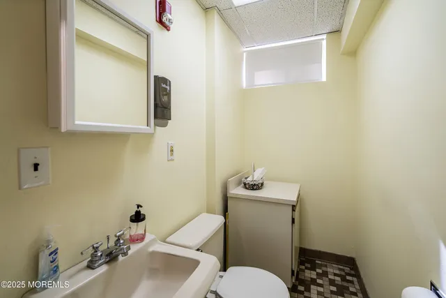 a bathroom with a sink mirror and toilet