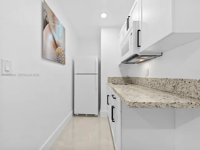 a kitchen with stainless steel appliances granite countertop a sink and a refrigerator