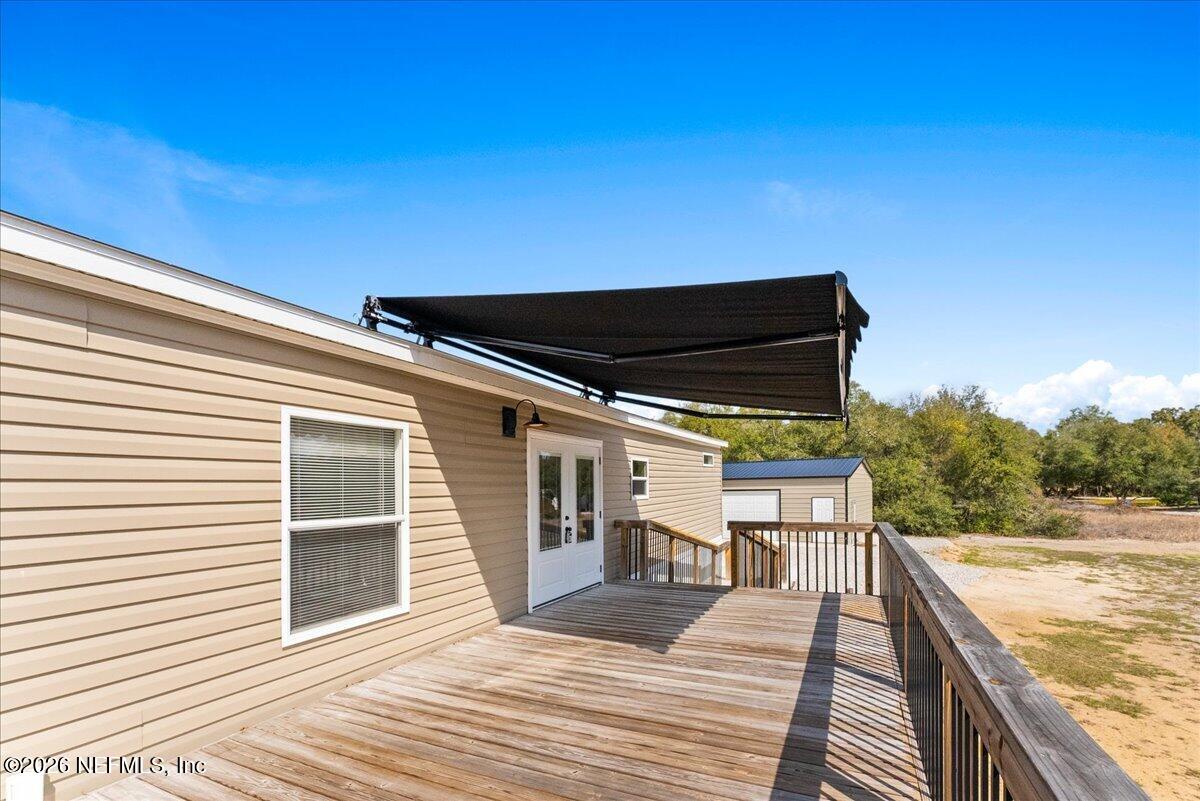 5533 Coronado Street Keystone Heights, FL 32656 - Photo 12 of 73 a view of a balcony with wooden floor and iron fence