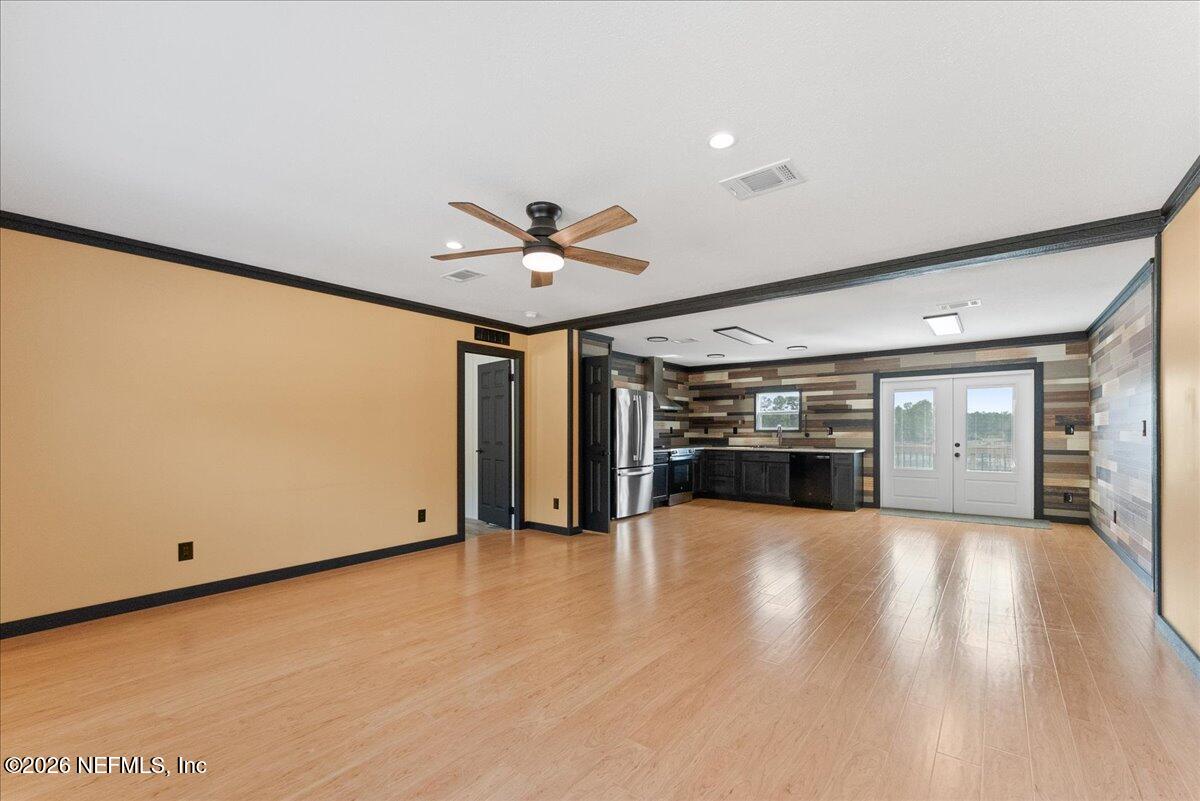 5533 Coronado Street Keystone Heights, FL 32656 - Photo 20 of 73 a view of an empty room with window wooden floor and a kitchen